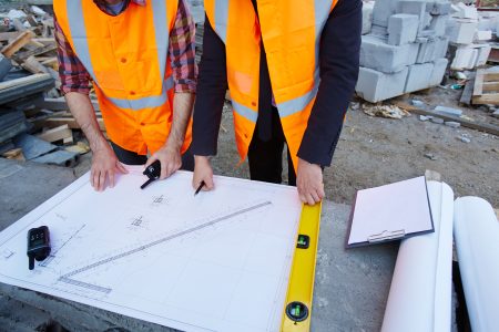 Two contractors discussing sketch of new building